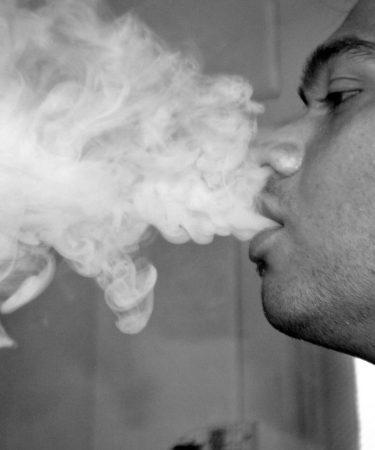 foto-bianco-nero-ragazzo-di-profilo-che-soffia-fumo-dalla-bocca