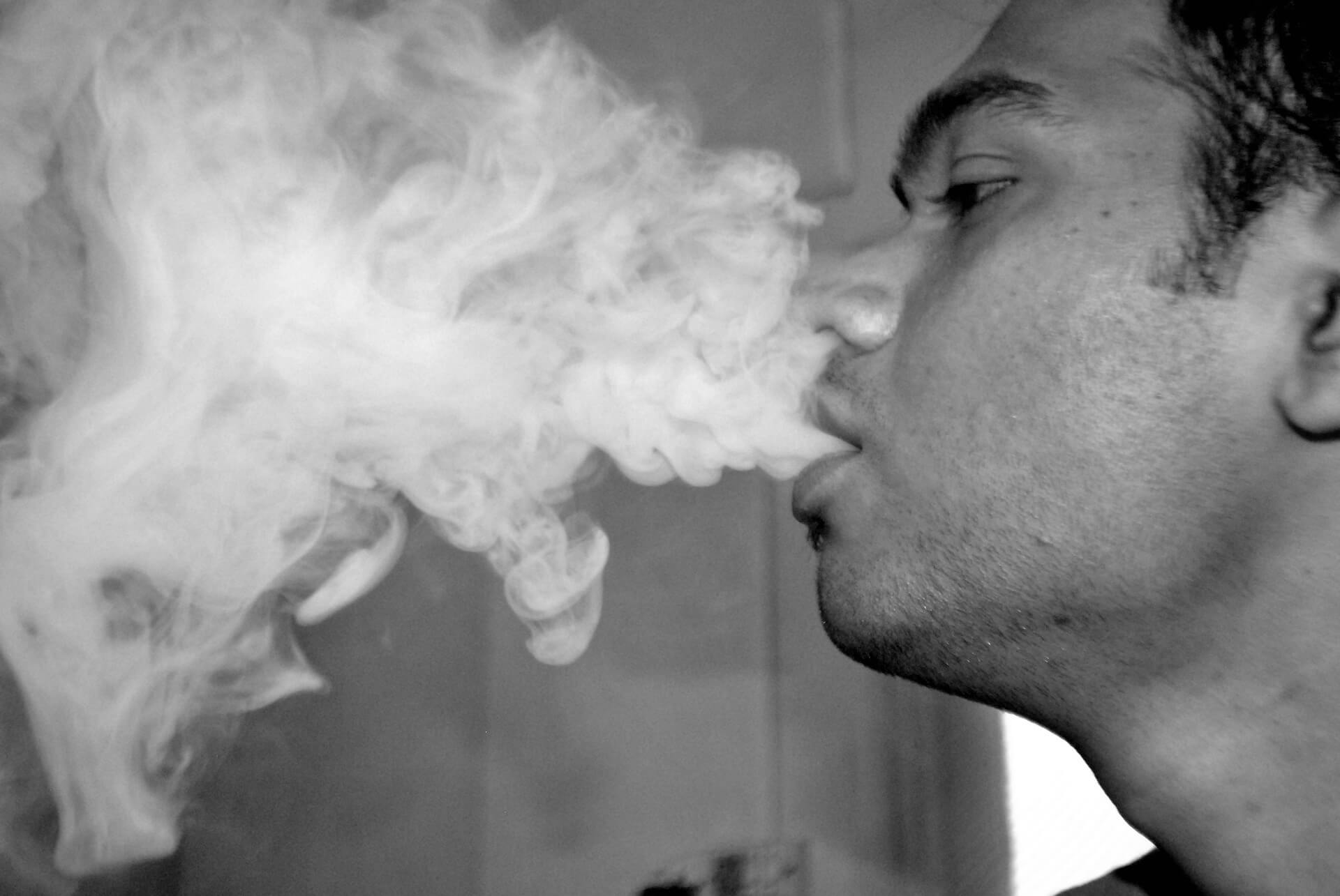 foto-bianco-nero-ragazzo-di-profilo-che-soffia-fumo-dalla-bocca